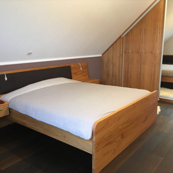 Massivholz-Schlafzimmer in Kernbuche mit Schiebetürschrank in der Schräge